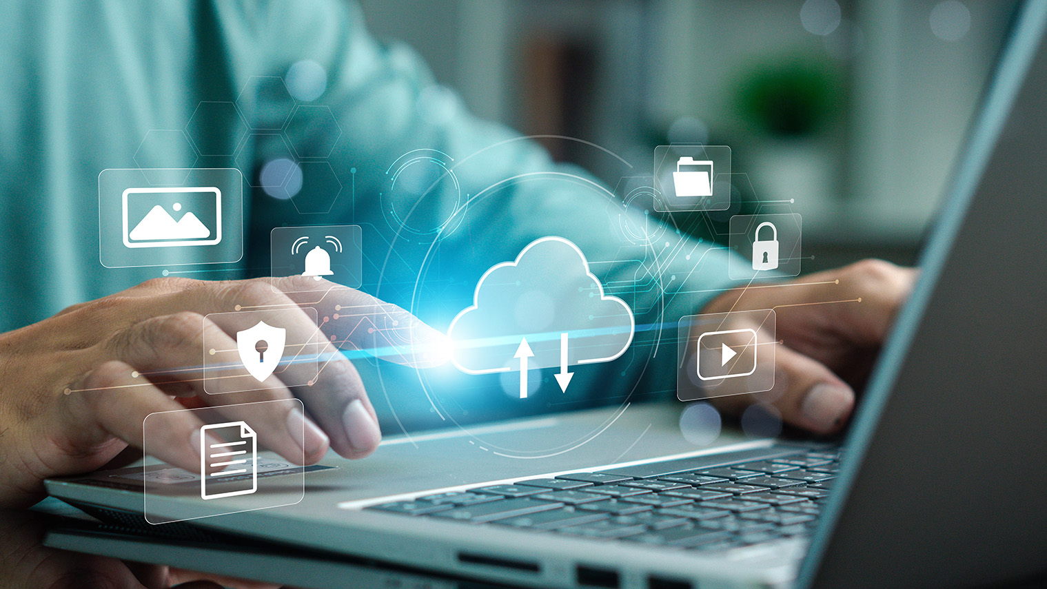 Hands typing on a laptop with illustrated cloud services