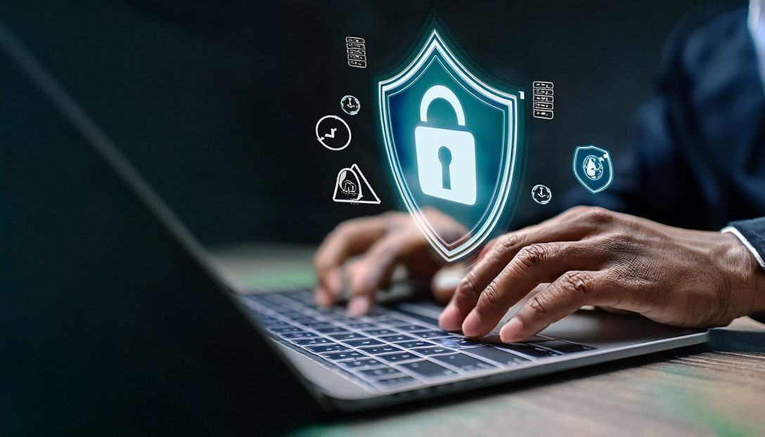 Person using a laptop with a digital shield and lock graphic
