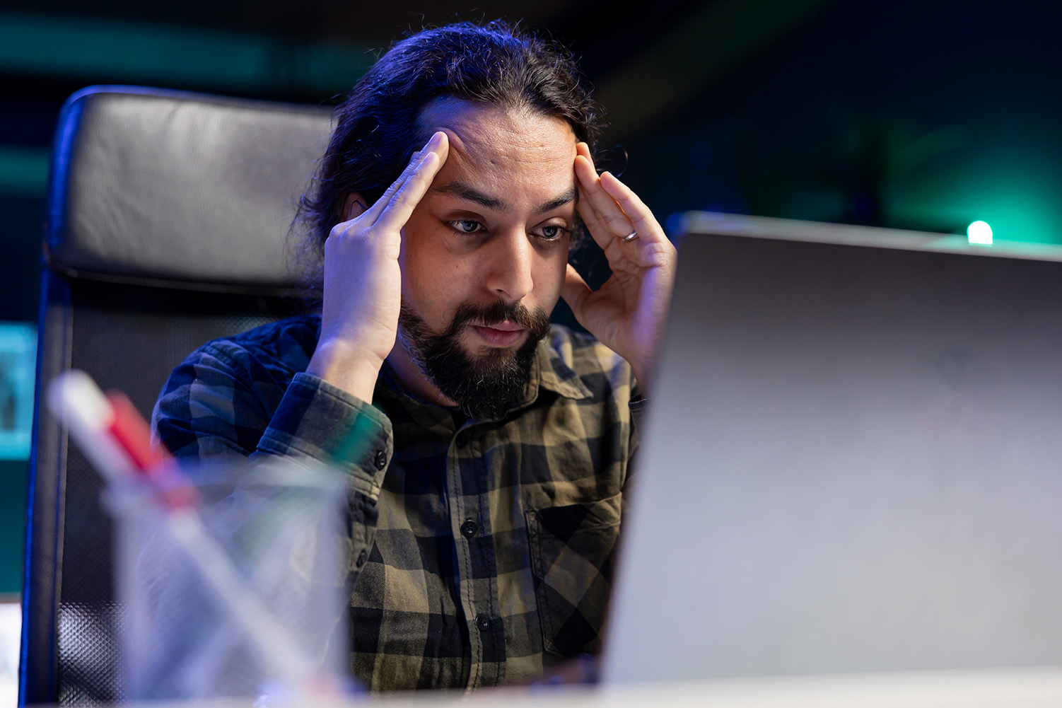 Person looking concerned while working at a laptop