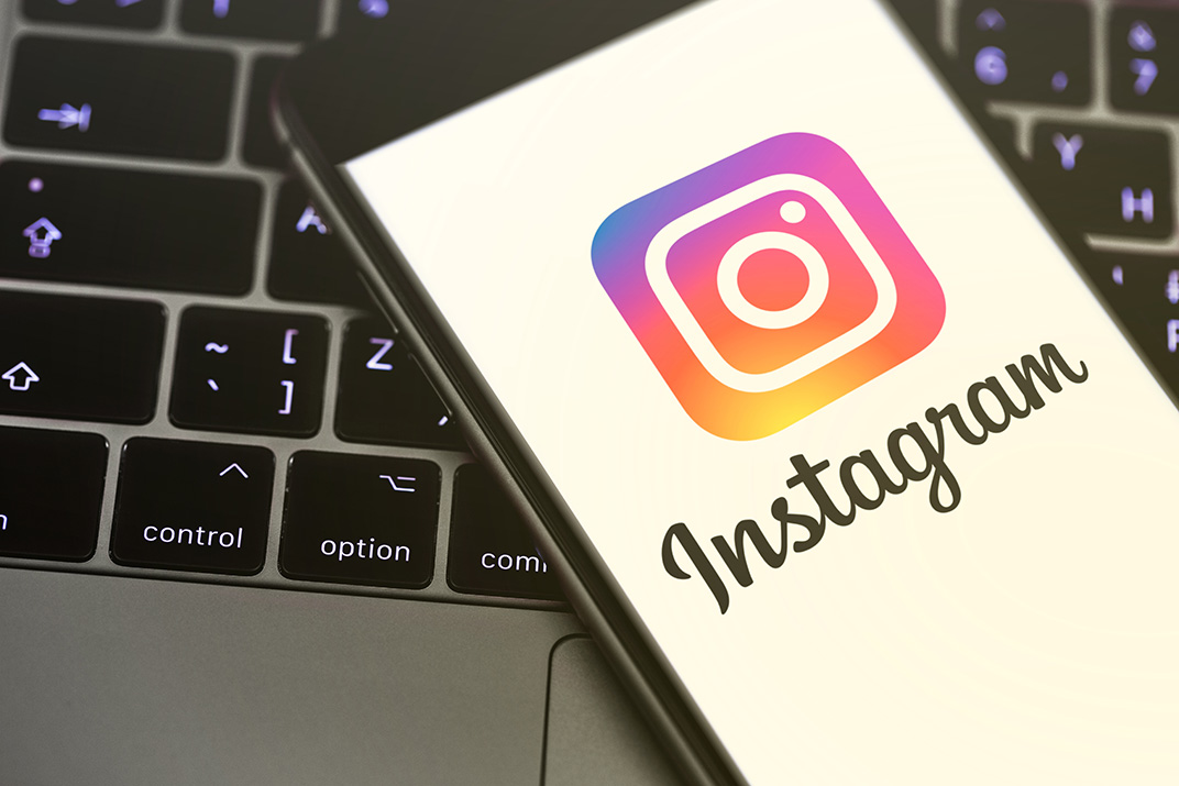 Phone displaying the Instagram logo on a laptop keyboard