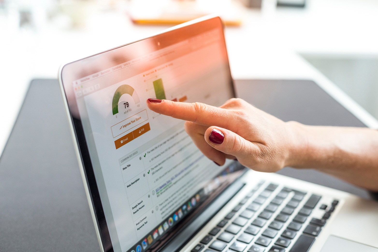 Person pointing at an SEO report on a laptop screen