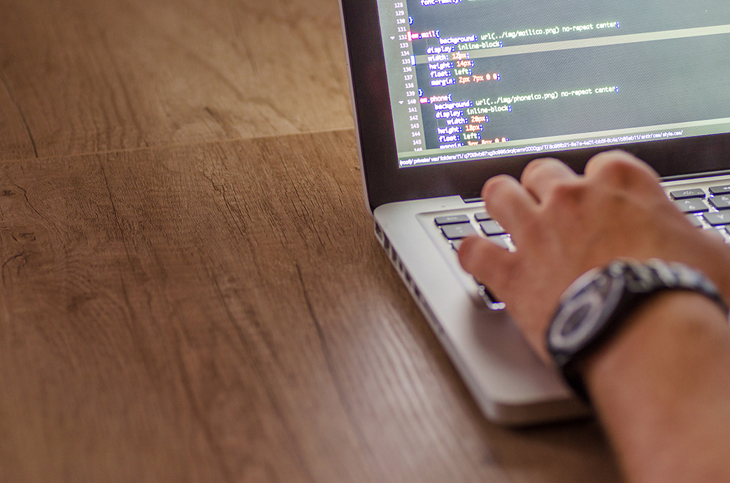 Person working on a laptop displaying code