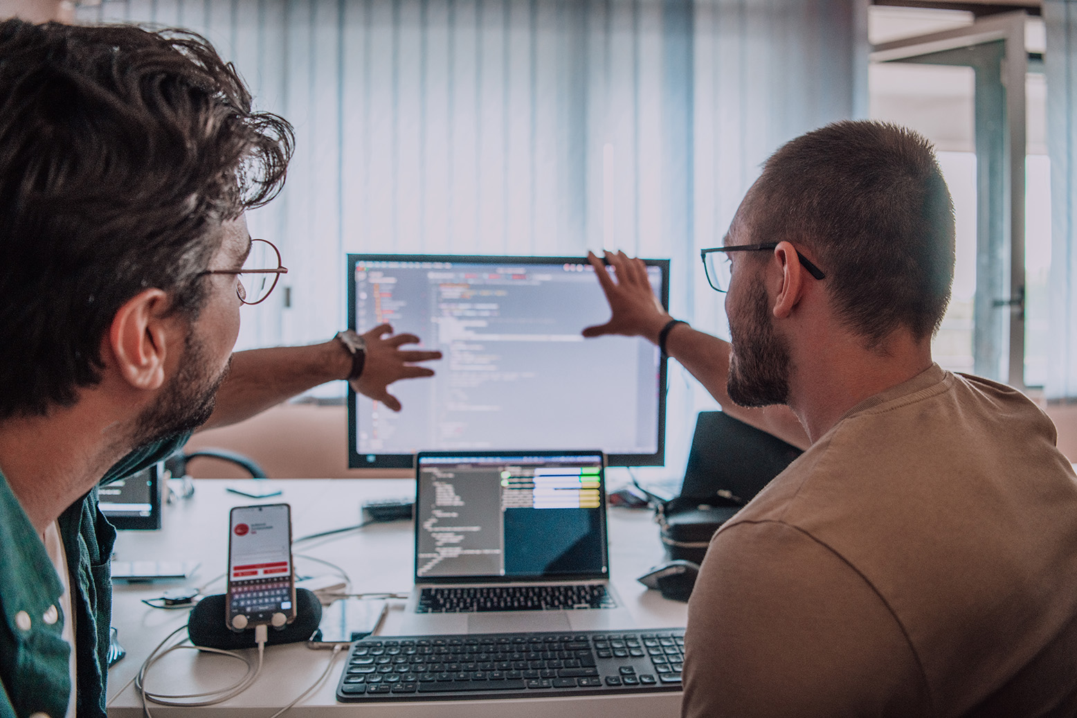 Two developers reviewing code on computer screens