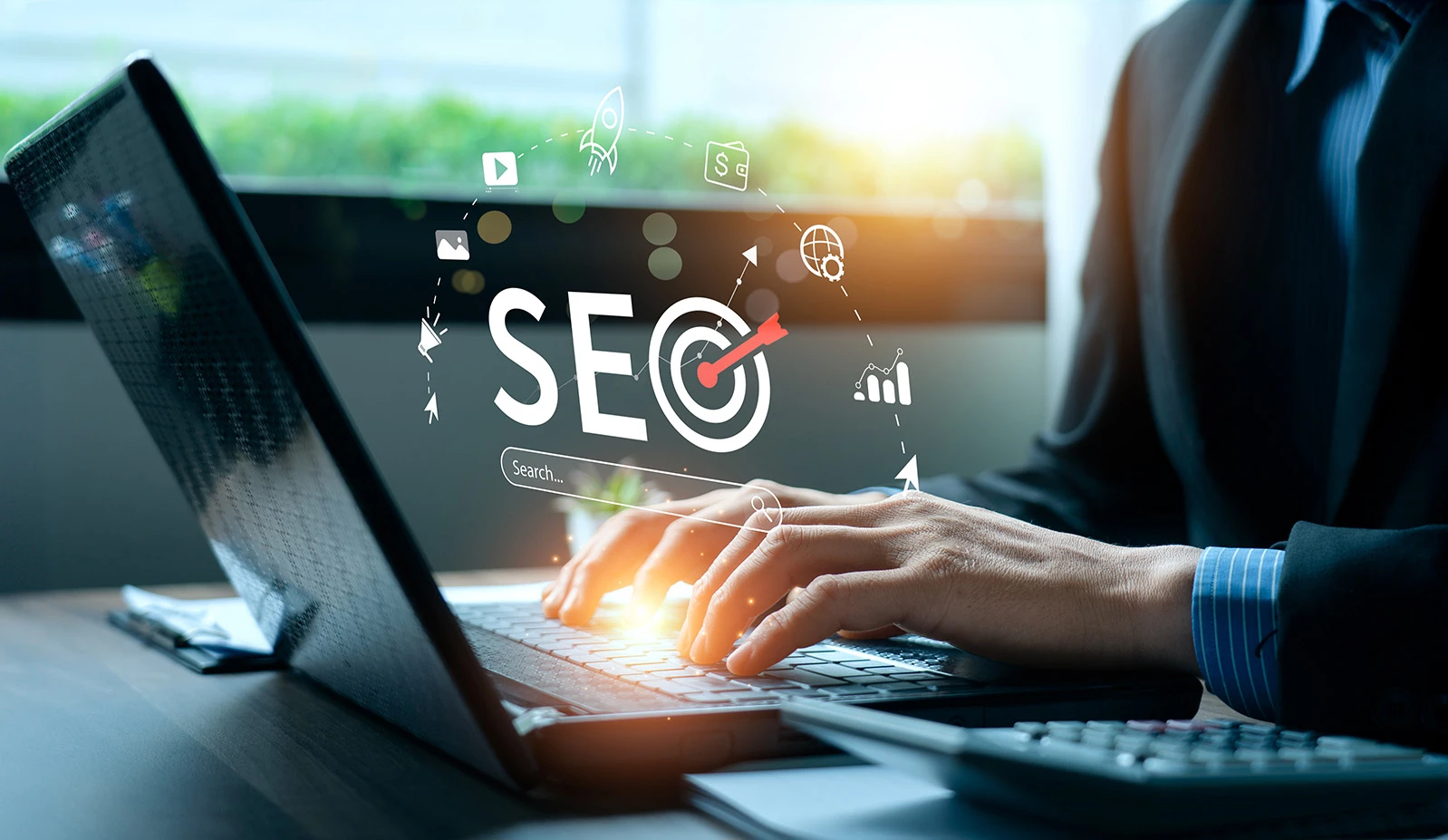 Person working on a laptop with an SEO and target graphic